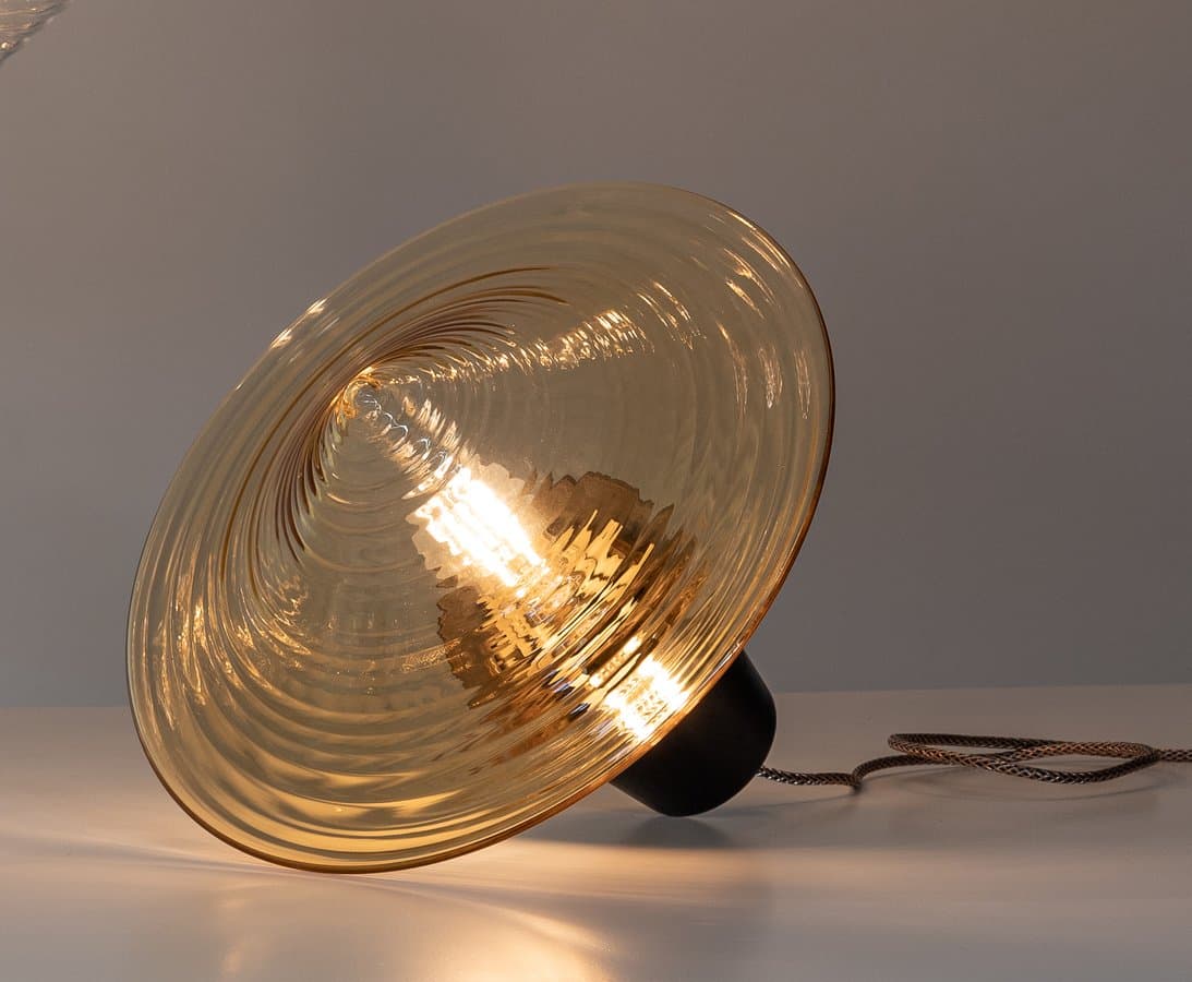 Disca-T glass table lamp in warm light.