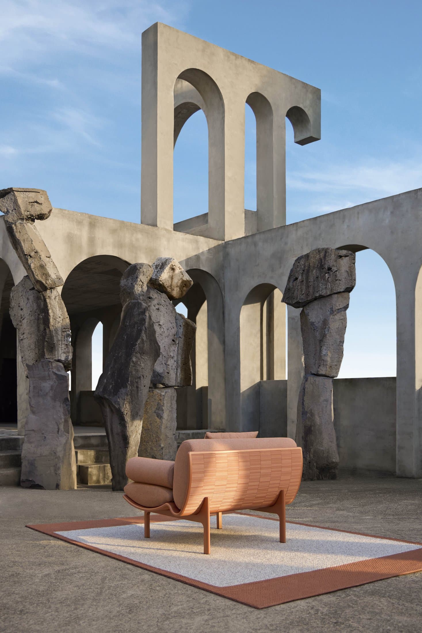 Dunne lounge chair in cuprum in an arched courtyard.