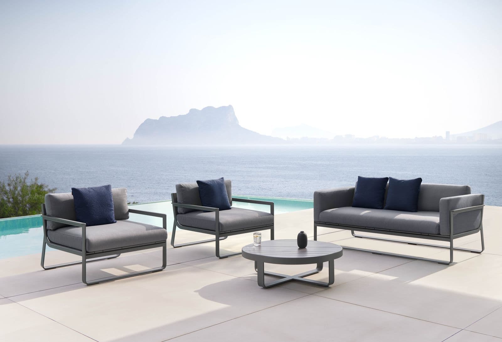 Flat lounge chair with round coffee table and two-seat sofa, anthracite.