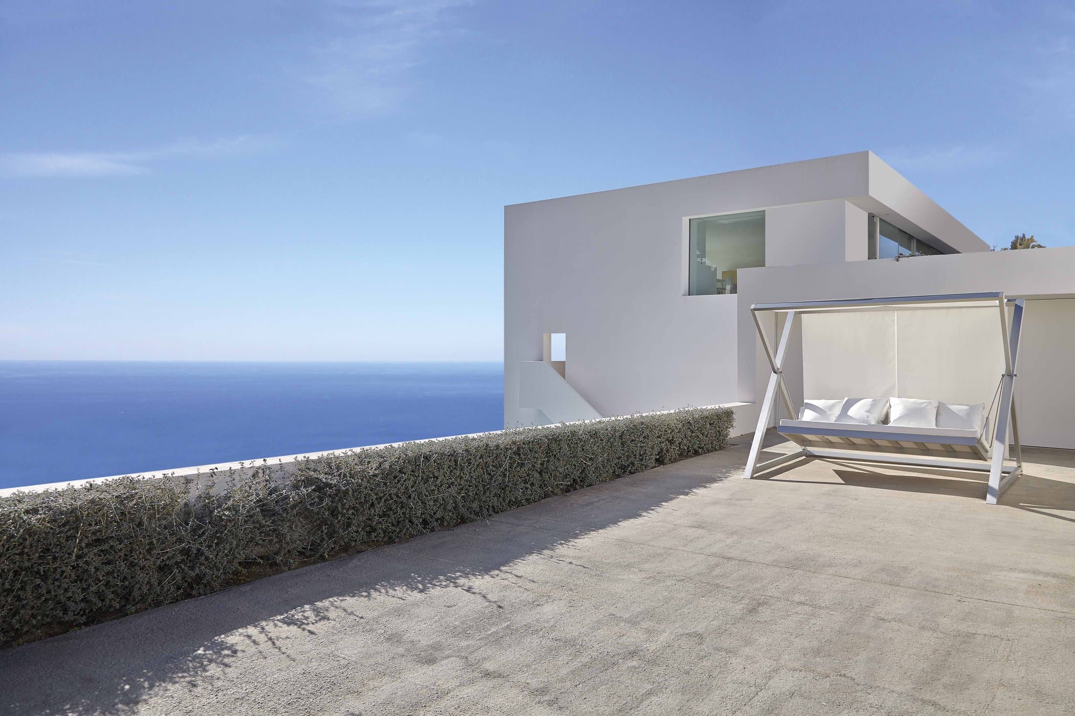 Nao Nao garden swing in white on a terrace above the sea.