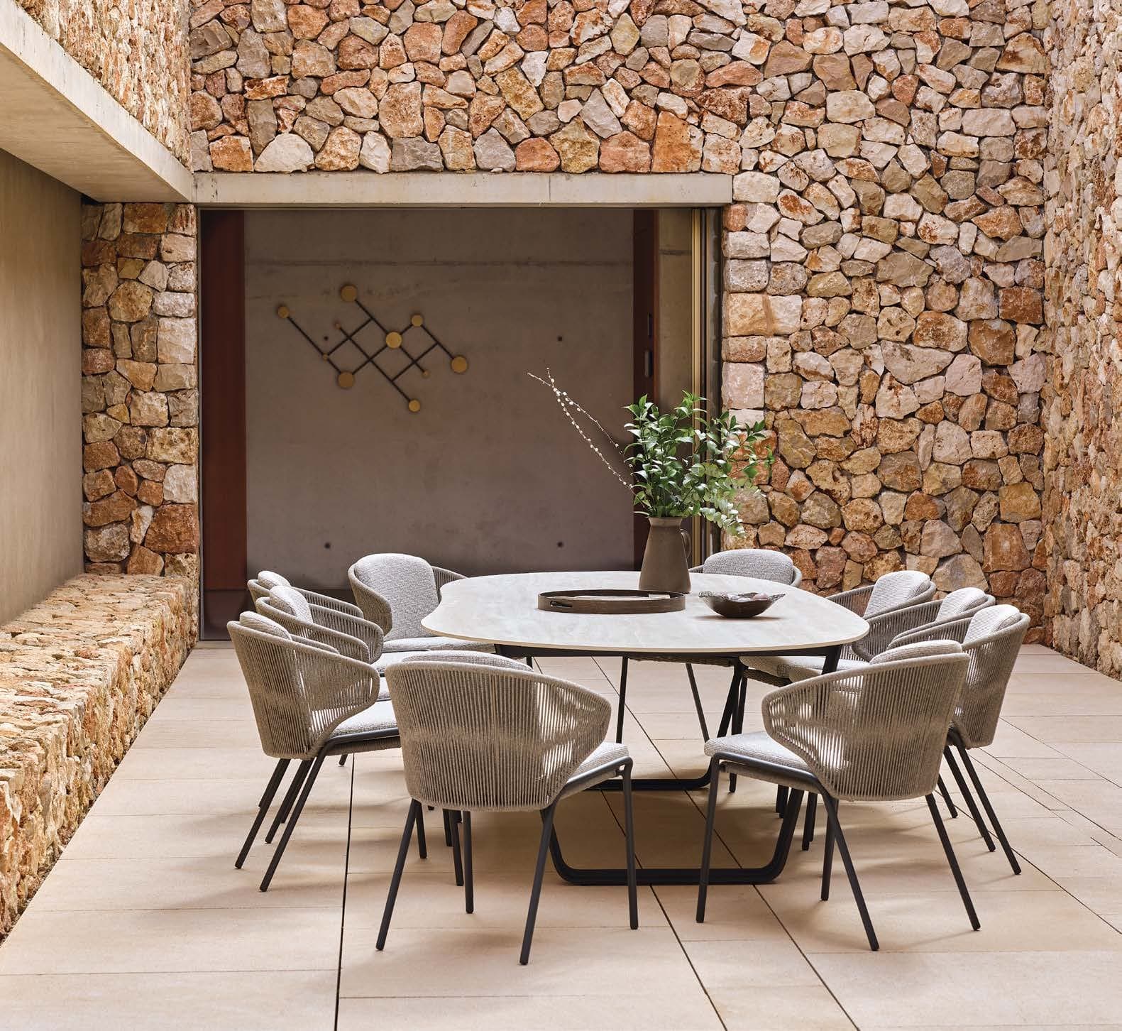Air table with woven chairs in a stone courtyard.