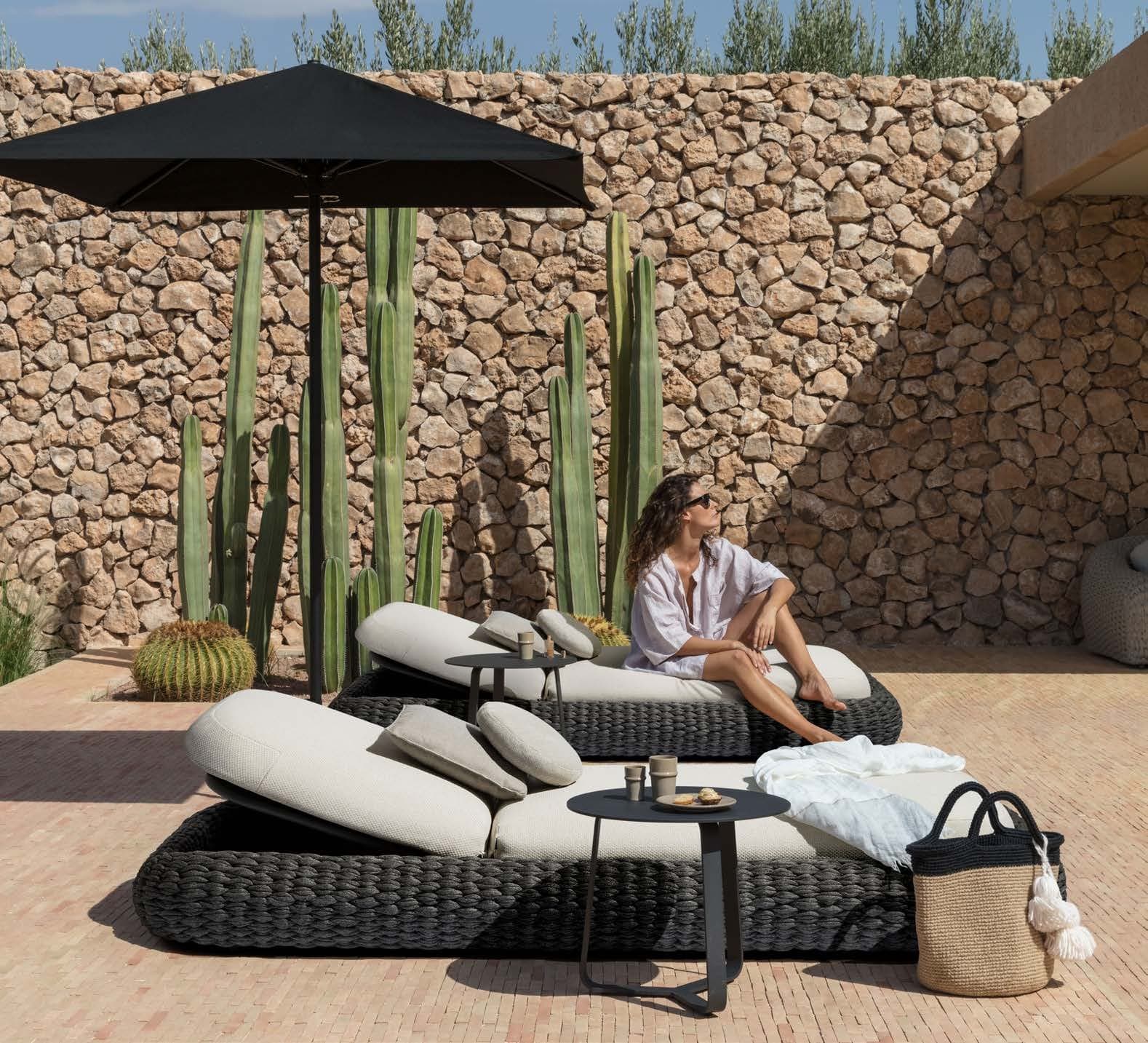 Giro table with a daybed under a black parasol.