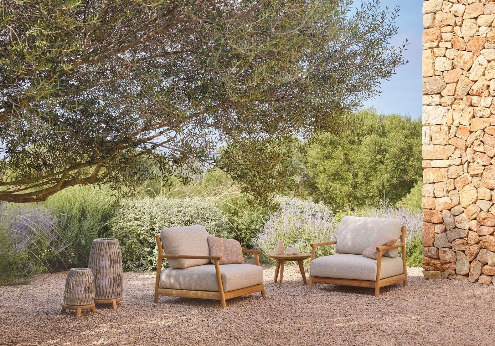 Manutti Muyu armchair beside a dry-stone wall.