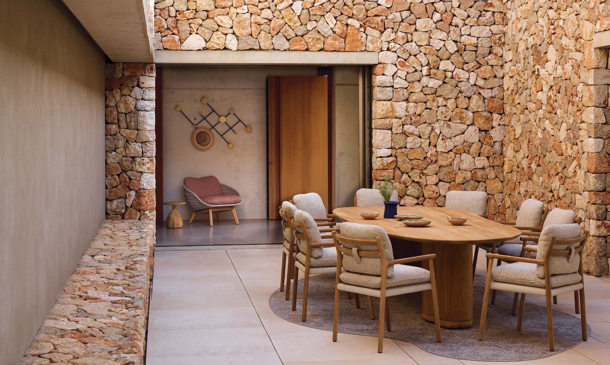 Ogado dining table set for dinner at sunset overlooking the sea.