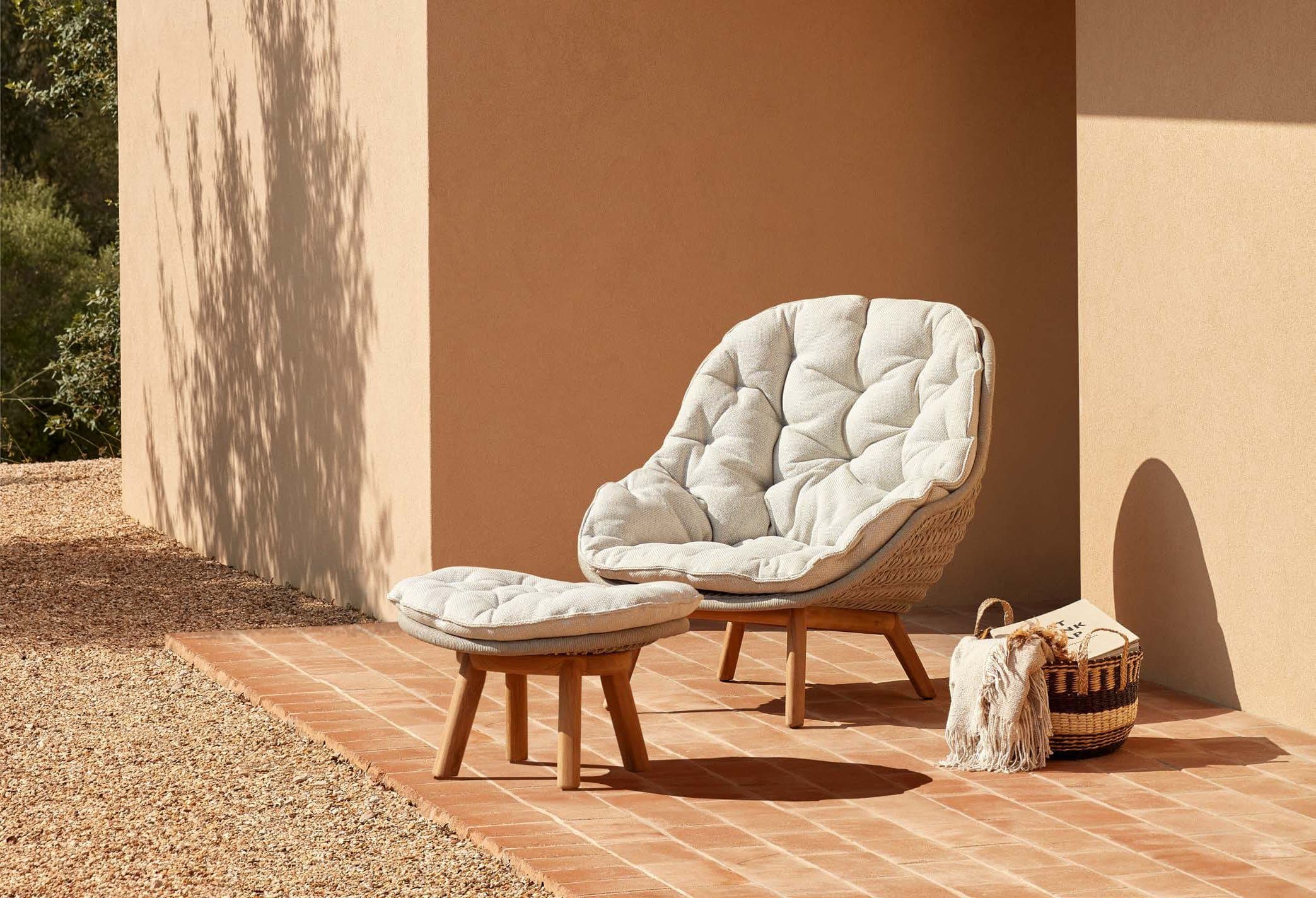 Manutti Sandua papasan lounge chair with ottoman in a plaster archway.