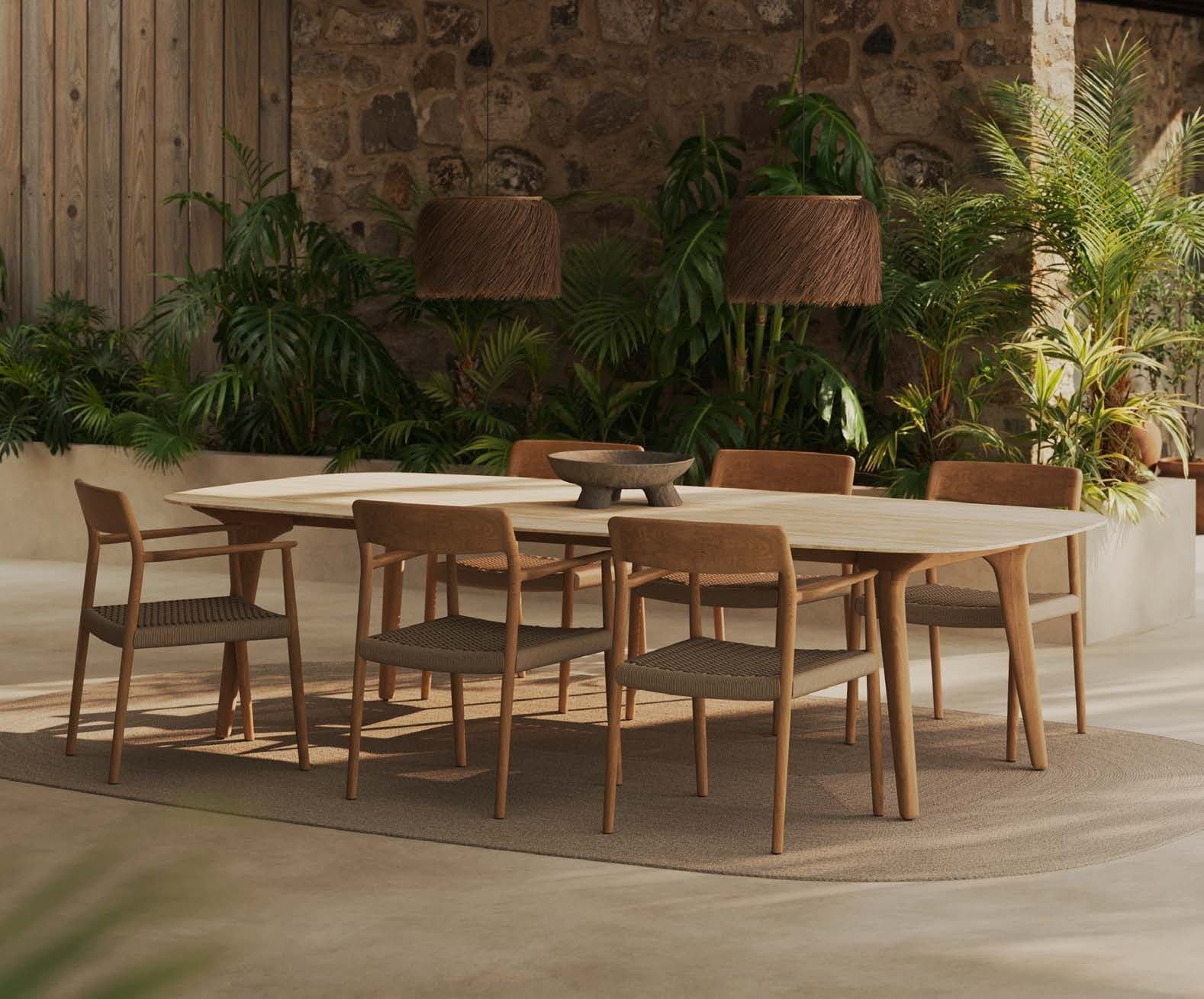 Tamo dining chairs around a table in a planted courtyard.